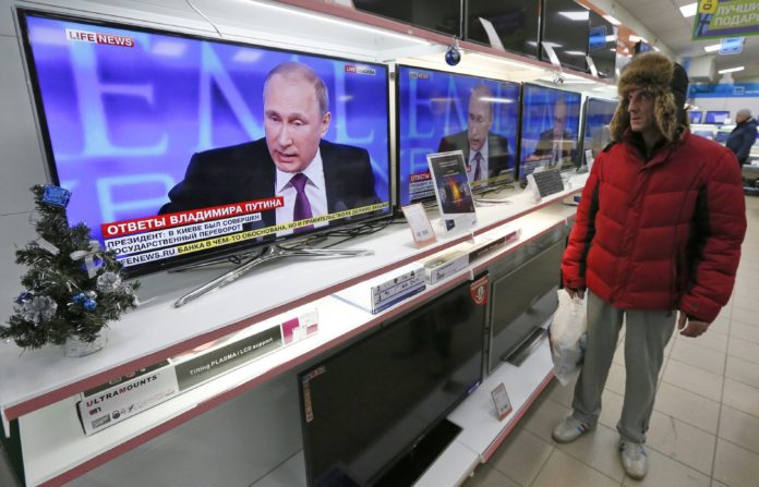 Путин на экране телевизора Фото: Reuters
